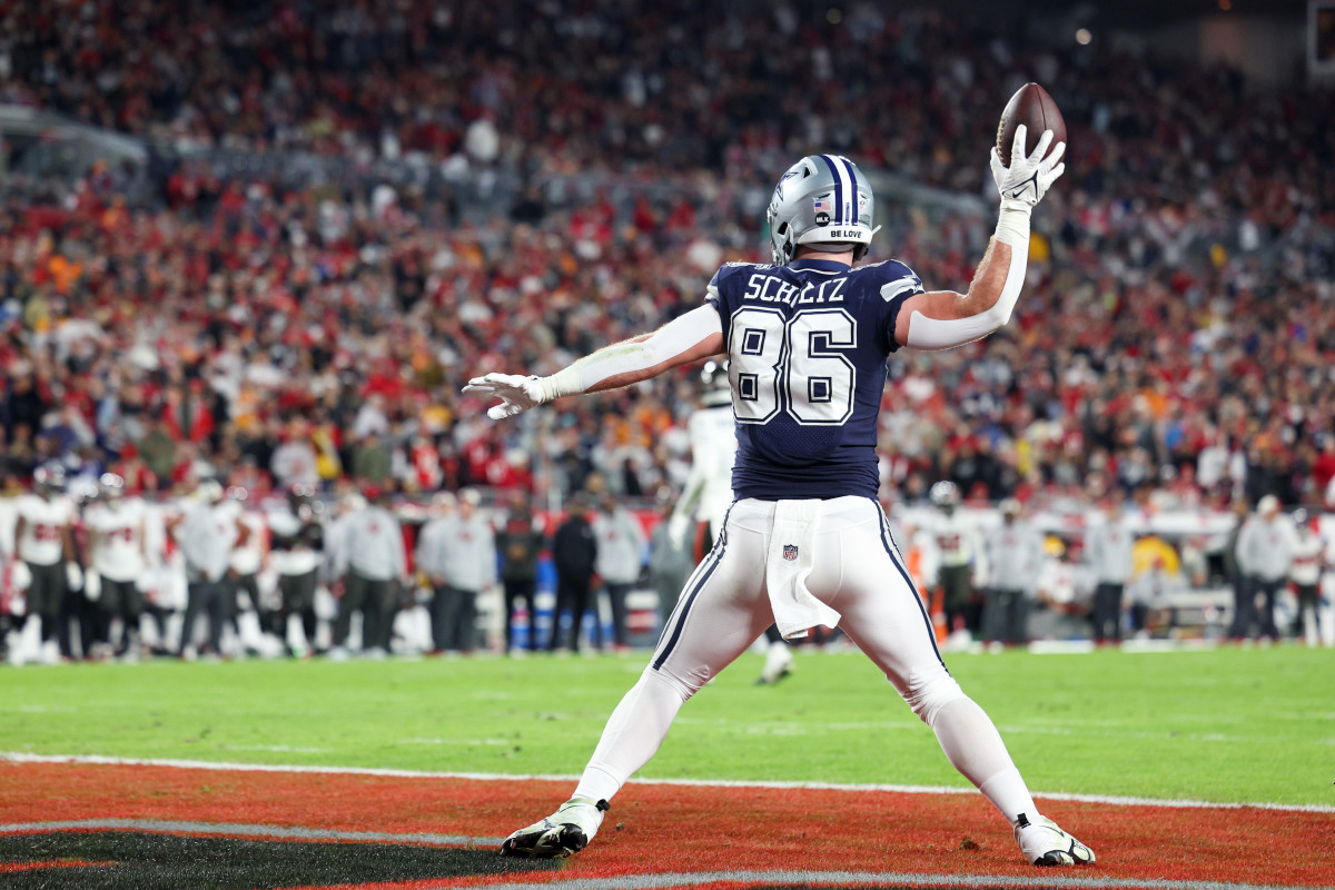 Dalton Schultz holds the ball high in his right hand as if to wind up to spike it into the ground